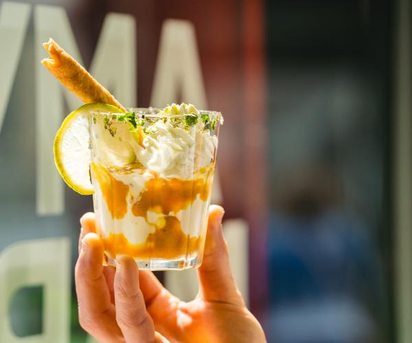Romig muntijs met rum-karamelsaus, afgewerkt met vers geklopte slagroom, limoen munt, rietsuiker en zeewier.